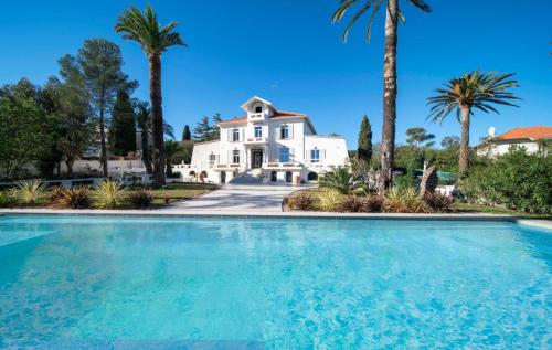une grande piscine en face d'une maison blanche dans l'établissement Villa Belle Epoque Saint-Raphaël, à Saint-Raphaël