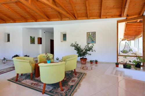 a living room with a table and yellow chairs at Hotel Kanione in Çorovodë