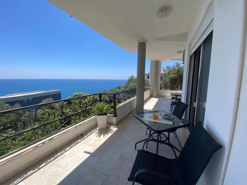 a balcony with a table and chairs and the ocean at Guesthouse HHL - Liman ll in Ulcinj