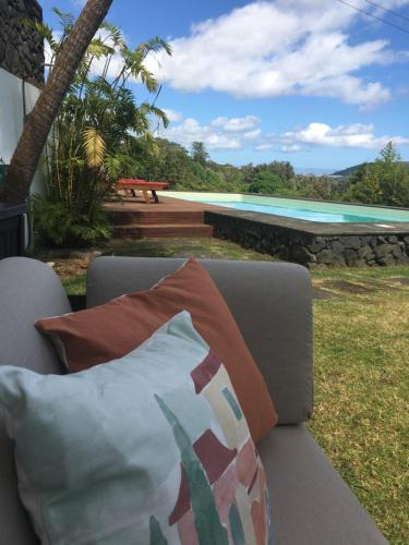 a pillow sitting on a couch next to a swimming pool at Casa do Pombal in São Mateus