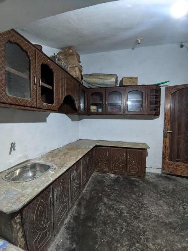 a kitchen with a sink and wooden cabinets at Riasat Home Stay - Nathia Gali Road in Bāzār