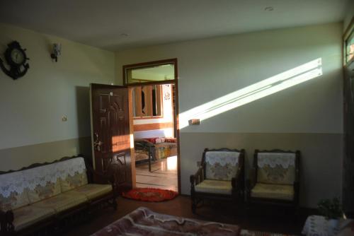 a living room with two chairs and a open door at Riasat Home Stay - Nathia Gali Road in Bāzār
