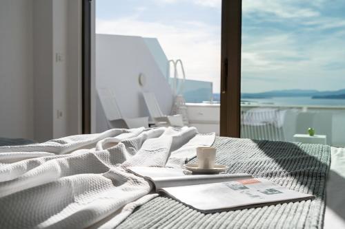 a bed with a book and a cup of coffee on it at Lagon Life Spirit Boutique Hotel - Adults Only in Chania Town