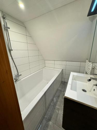 a white bathroom with a tub and a sink at Ferienwohnung Mixnitz-Bärenschützklamm 1 in Mixnitz