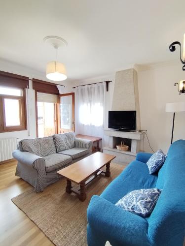 a living room with two blue couches and a coffee table at Covas Beach Ocean in Lago
