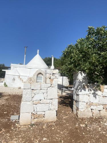 a stone building with a tree in front of it at Trullo Moi in Ostuni