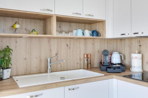 une cuisine avec des armoires blanches et un évier dans l'établissement Luxe, vue mer et parking privé, à Marseille