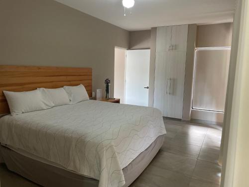 a bedroom with a bed with a white comforter at AVE SUITES CAMPESTRES Jalpan de Serra in Cunas