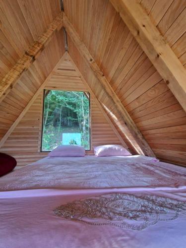a large bed in a attic with a window at Mountain View in Foča