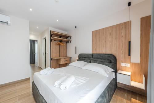 a bedroom with a large white bed with white pillows at Sea La Vie Suites in Golem