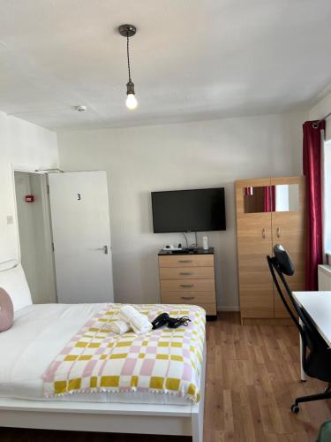 a bedroom with a bed and a flat screen tv at Lovely Rooms in Camden Town-Central London in London