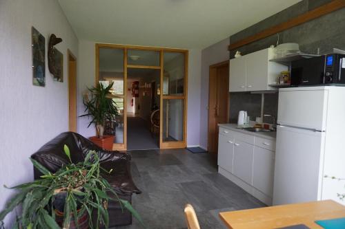 a kitchen with a white refrigerator and a table at Waldhotel Weitblick in Fichtach