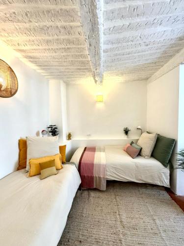 deux lits dans une chambre avec un plafond dans l'établissement Charming house in Valbonne village, à Valbonne