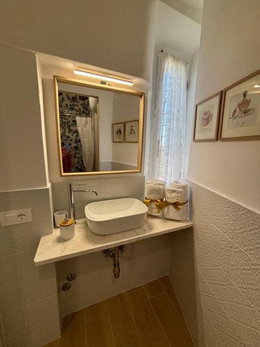 a bathroom with a sink and a mirror on a counter at Casa Vacanze La Donna di Cuori in Volterra