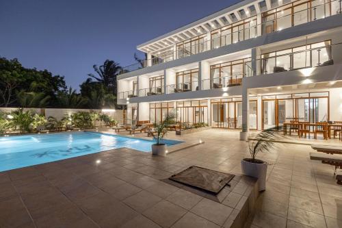 an exterior view of a building with a swimming pool at YU Resort in Msambweni