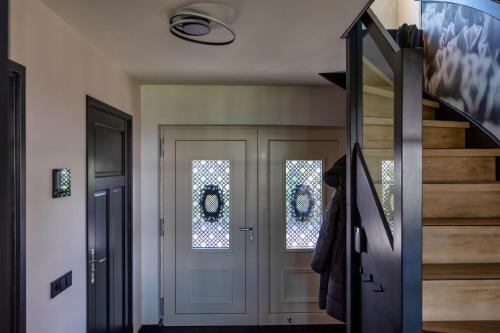 a hallway with a white door and a staircase at Villa Savannah in Roelofarendsveen