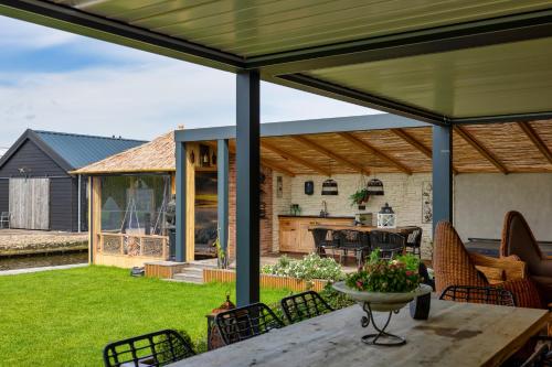 an open patio with a table and chairs at Villa Savannah in Roelofarendsveen