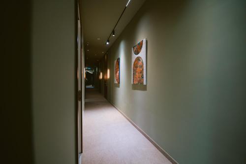 a hallway with paintings on the walls of a building at Noemie Hotel in Himare