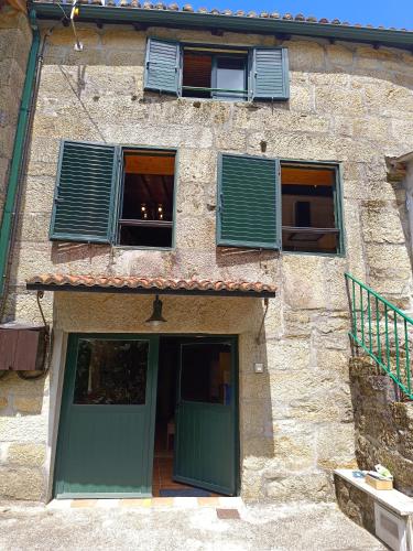 a building with a green door and two windows at Luz do Sil in Ourense