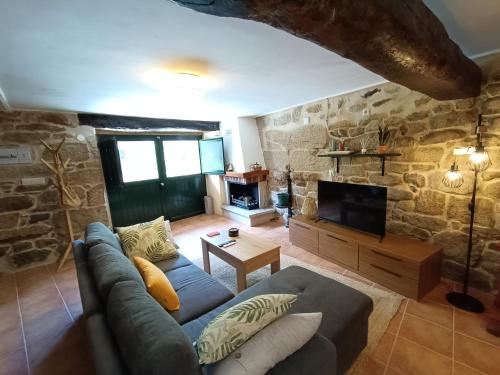 a living room with a couch and a tv at Luz do Sil in Ourense