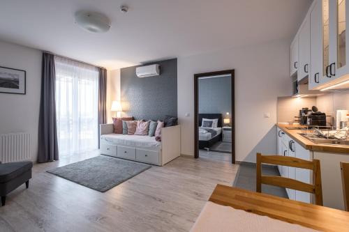 a kitchen and living room with a couch in a room at Aranymandula apartmanok in Balatonakali