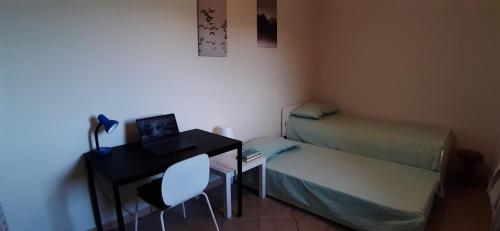 a small room with a desk and a bed and a laptop at EMALU - Workation&Holiday in Pinerolo