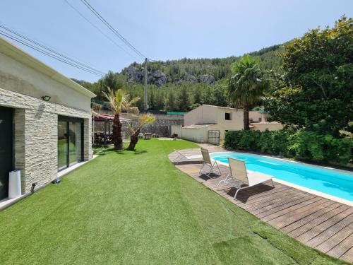 une cour avec une piscine et deux chaises dans l'établissement Villa neuve avec Piscine Privée Parc des Calanques 15min Vélodrome, à Marseille