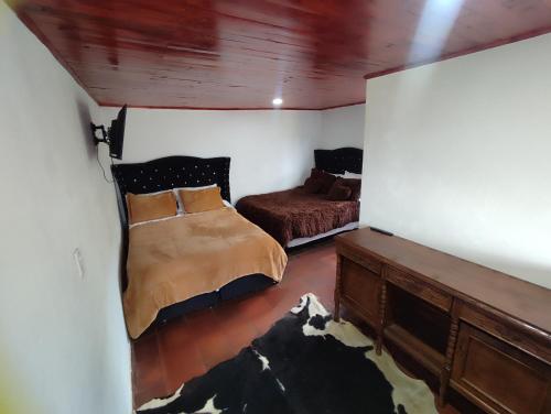 a bedroom with a bed and a couch in it at Cabañas Casa Campo Guatavita in Guatavita