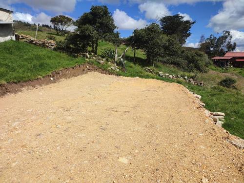 a dirt road in the middle of a field at Cabañas Casa Campo Guatavita in Guatavita