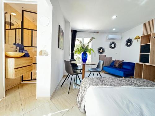 a bedroom with a blue couch and a table with chairs at Villa Belle Epoque Saint-Raphaël in Saint-Raphaël