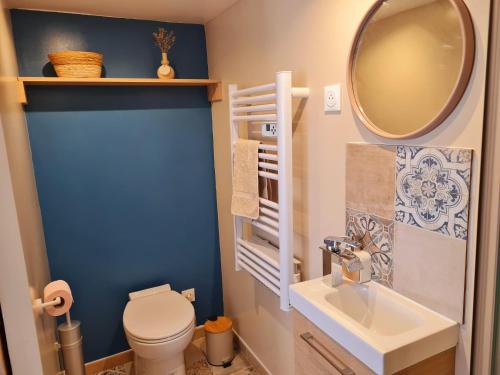 Un baño con inodoro, lavabo y espejo. en Le Gallieni, en Bron