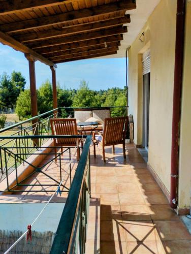 a balcony with two chairs and a table at Yucca house in Elani