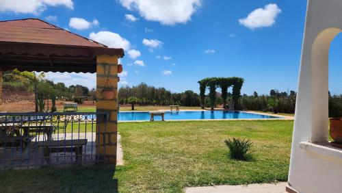 a swimming pool in a park with a gazebo at Villa, piscine sans vis-à-vis in Casablanca