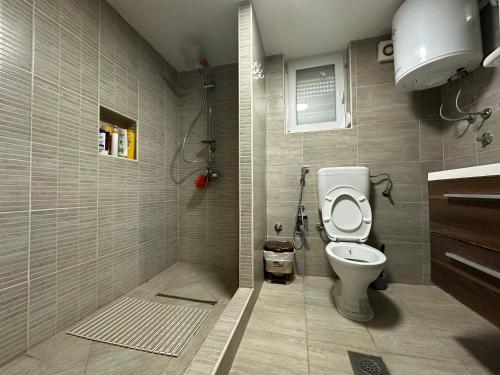 a small bathroom with a toilet and a shower at Happy House in Sarajevo