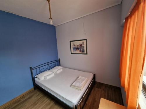a small bed in a room with a blue wall at SleepEasy in Athens