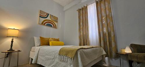 ein Schlafzimmer mit einem Bett und einem Fenster in der Unterkunft Kaye Sace Terrace in Castries