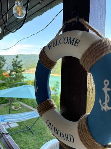a welcome rope tied to a pole with a welcome on board sign at Lake View Cottage - Zavojsko jezero in Zavoj