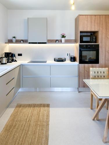 a kitchen with white cabinets and a table and a counter at Maistros Villa in Rodakino