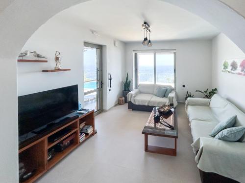 a living room with a couch and a tv at Maistros Villa in Rodakino