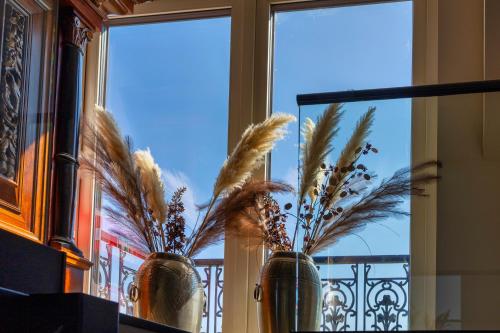 two vases with plants in them in a window at Villa Savannah in Roelofarendsveen