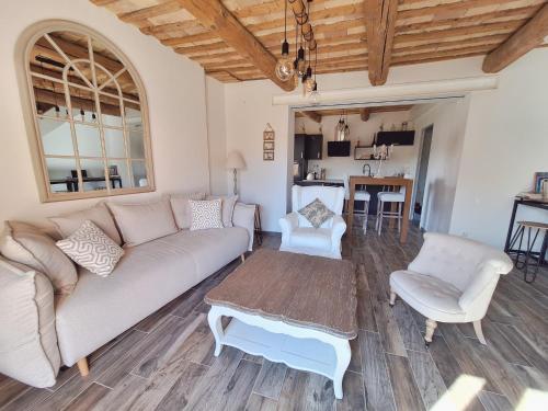 un salon avec un canapé et une table dans l'établissement Maison de charme village entre Vignes et Lavandes, à Le Pin