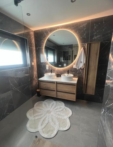 une salle de bain avec deux lavabos et un grand miroir dans l'établissement Villa Aqua Détente, à Ingersheim