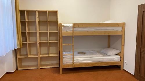 a bunk bed room with two bunk beds and shelves at Turistická chata Libínské Sedlo in Prachatice