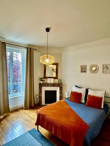 - une chambre avec un lit doté d'oreillers rouges et une cheminée dans l'établissement Akwaba Nancy, à Nancy