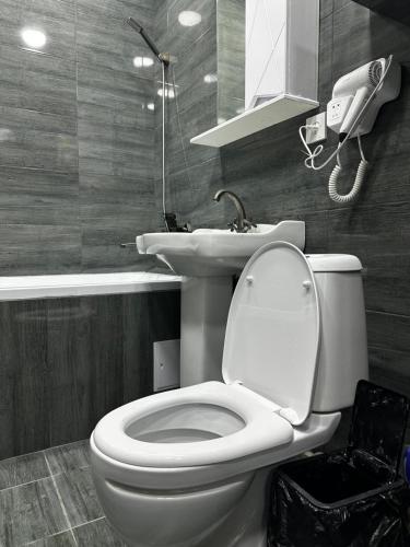 a bathroom with a toilet and a phone on the wall at 1 комнатная квартира Lux класса в центре Шымкента in Shymkent