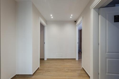 an empty hallway with white walls and wooden floors at Sea La Vie Suites in Golem