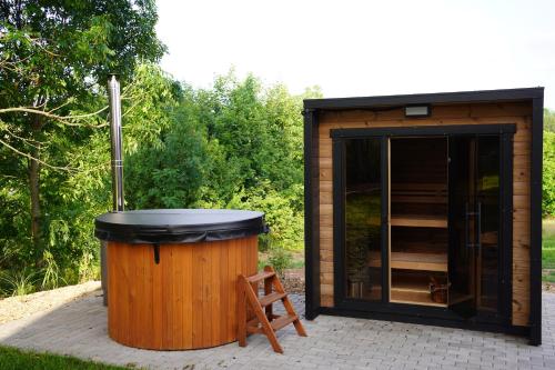 a small shed with a trash can in front of it at Rodinný apartmán Čistá in Cerny Dul