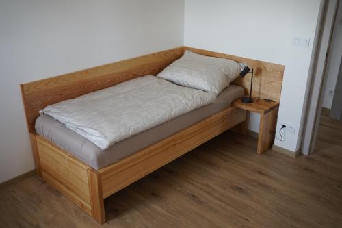 a bed in a room with a wooden frame at Rodinný apartmán Čistá in Cerny Dul