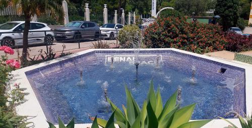 a swimming pool in a parking lot with parked cars at Benal Beach Vibe in Benalmádena