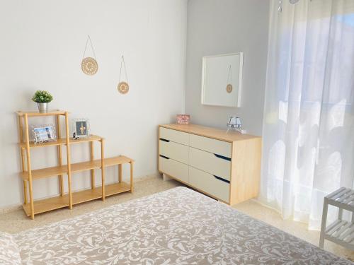 una camera da letto con cassettiera e specchio di Ático Sonnenschein a Jerez de la Frontera
